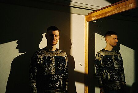 Arthur Clees steht vor einem Spiegel