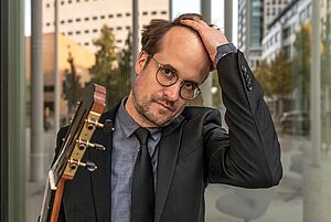 Portraitbild von Martin Steuber mit Gitarre