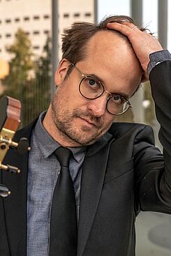 Portraitbild von Martin Steuber mit Gitarre