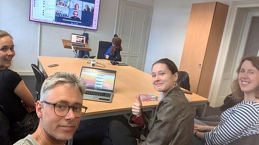Gruppenraum mit Studierenden und Dozent, die in einer Videokonferenz sind
