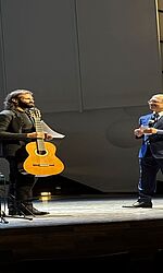 DAAD-Preis 2025 für den Gitarristen Ozan Coşkun/ Foto: Marie Kirchner Ozan Coşkun bekommt die Urkunde für den DAAD-Preis verliehen