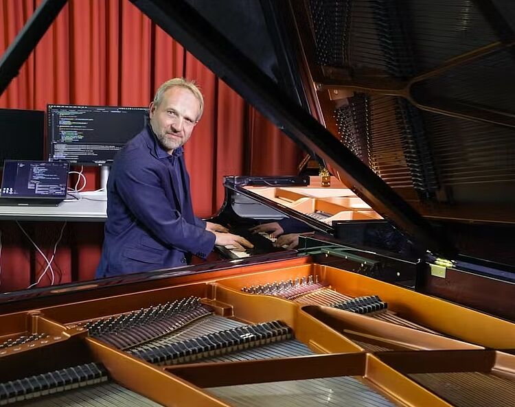 Prof. Dr. Martin Rohrmeier/Foto: Alain Herzog Martin Rohrmeier spielt vor einem offenen Klavier, to the current article