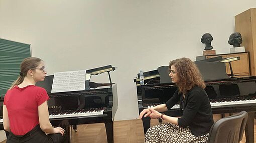 Mirjana Rajić erklärt einer Studentin etwas zum Klavierspiel