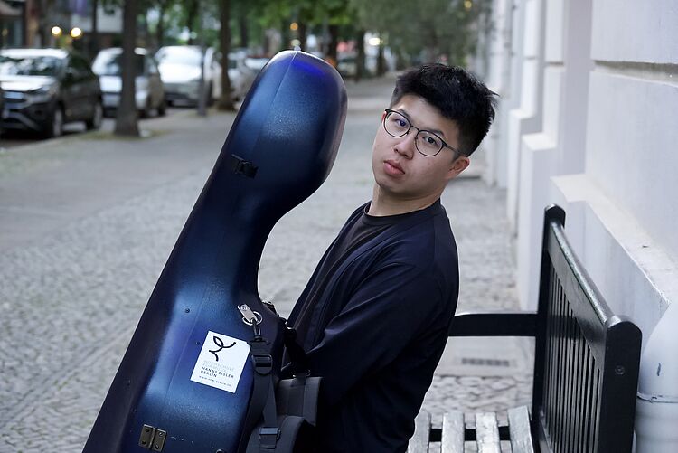 WenTeng Chang mit Cello auf Sitzbank