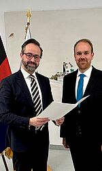 Wissenschaftsminister Sebastian Gemkow übergibt die Ernennungsurkunde an Dr. Michael Schmischke