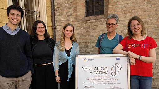Gruppenbild vor dem Konservatorium mit dem Plakat zum Kongress
