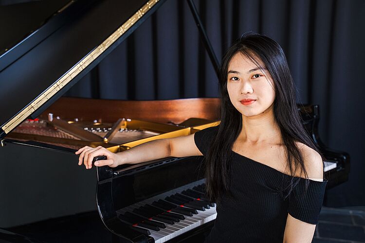 Shangyi Han mit Klavier, zum Aktuelles-Beitrag