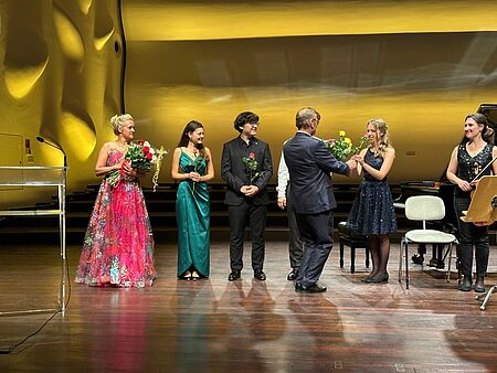 Applaus nach dem Konzert Chopin ohne Grenzen im Nikolaisaal Potsdam/Foto: Aleksandra Mikulska Studierende und Alexandra Mikulska bekommen auf der Bühne des Nikolaisaals Potsdam Blumen überreicht