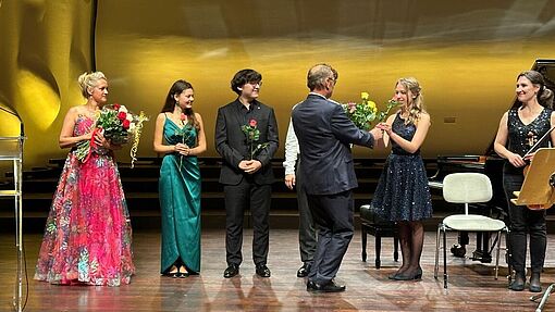 Studierende und Alexandra Mikulska bekommen auf der Bühne des Nikolaisaals Potsdam Blumen überreicht