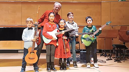 Gruppenbild der Kinder mit Gitarren-Professor Ralf Beutler