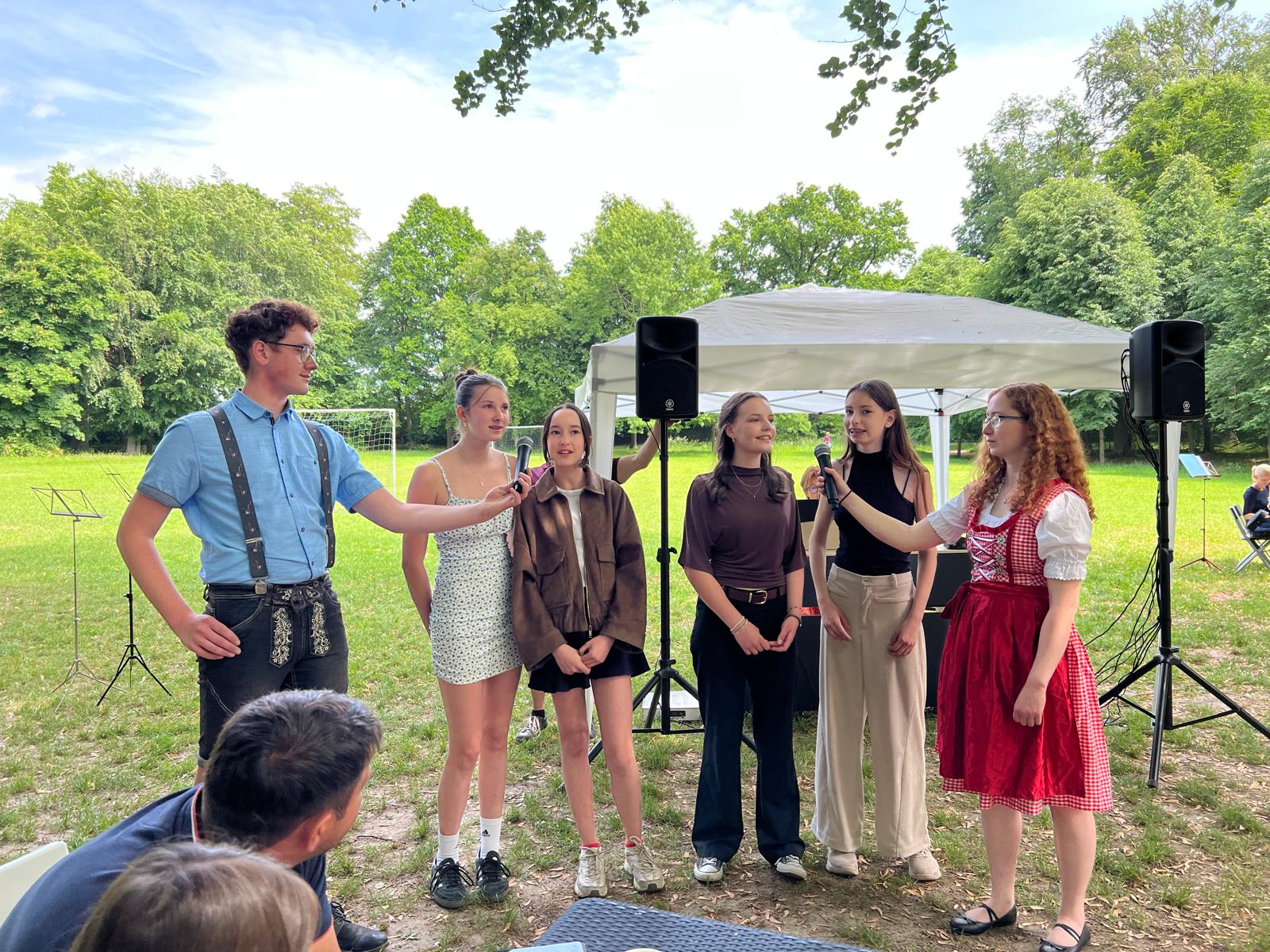 Schüler*innen der Kreismusikschule Bautzen bei einem Konzert der Reihe "Muszieren auf dem Lande" in Seifersdorf/Foto: Christiane_Kühn Schüler*innen stehen nebeneinander, bekommen ein Mikrofon gehalten und singen